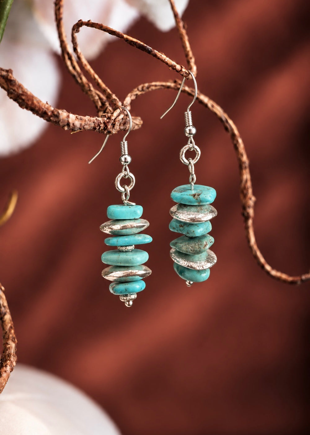 Genuine Turquoise Disc Earrings hanging from a branch