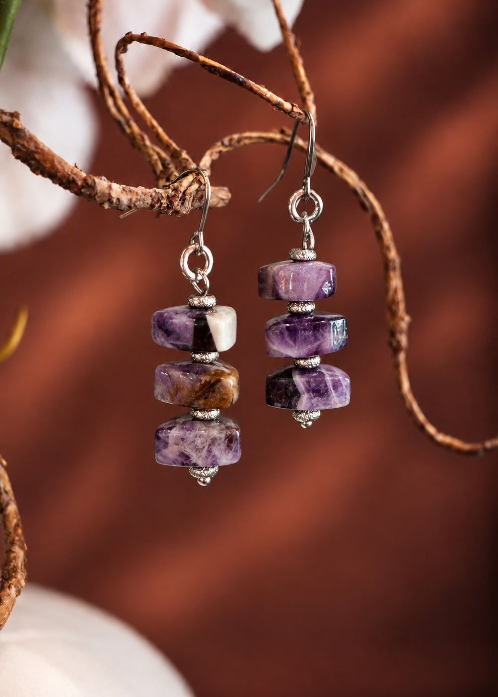 Chevron Amethyst Drop Earrings hanging from a branch