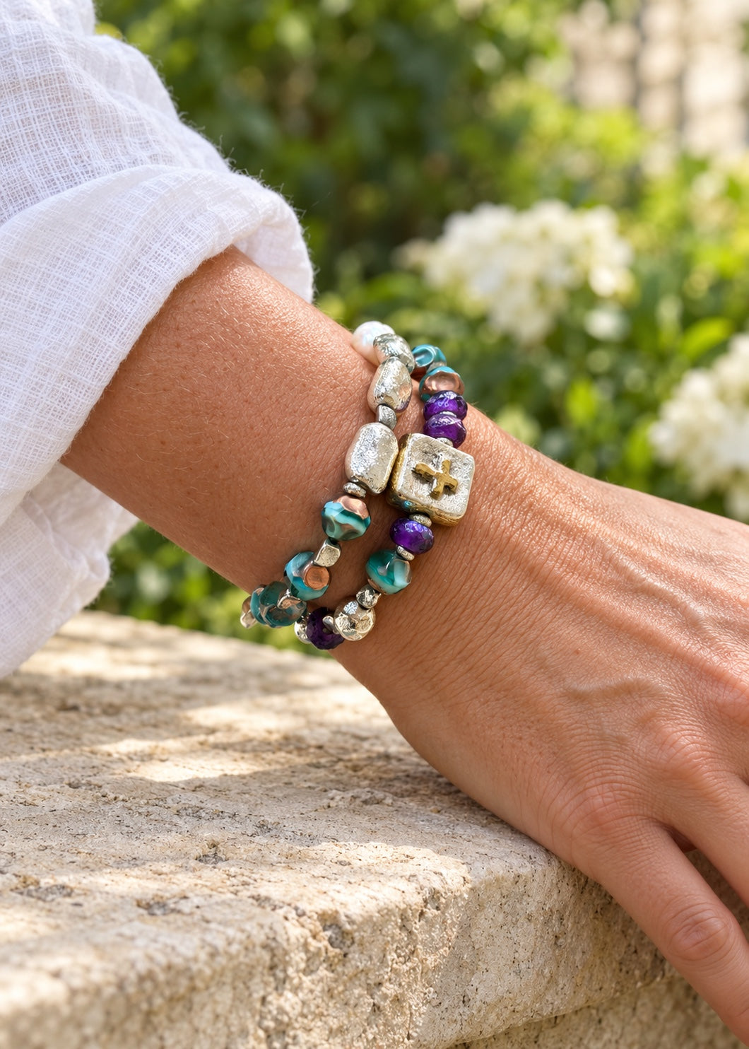 Silver Stepping Stones and Consider the Lilies bracelets worn together outdoors; bracelets sold separately