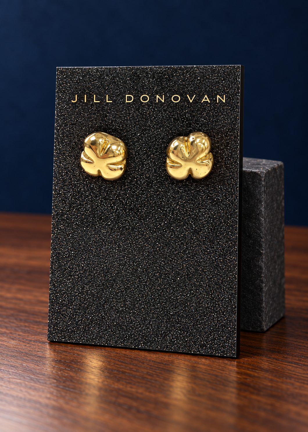 Cast brass flower stud earrings on a black Jill Donovan lucite card