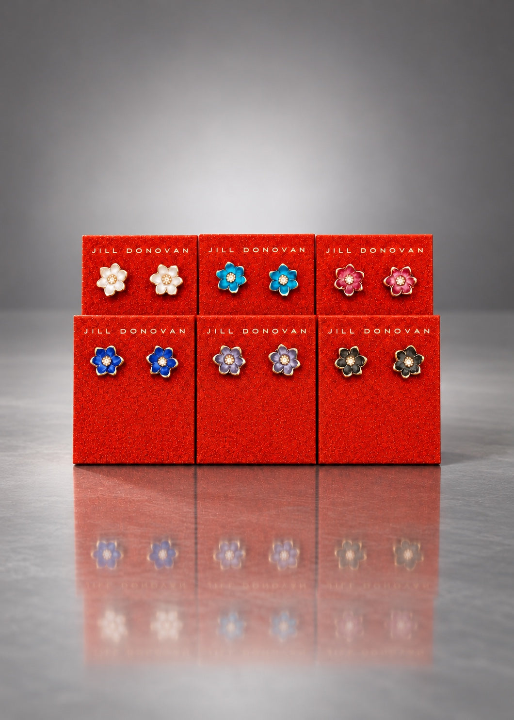 Magnolia resin stud earrings displayed on red Jill Donovan cards