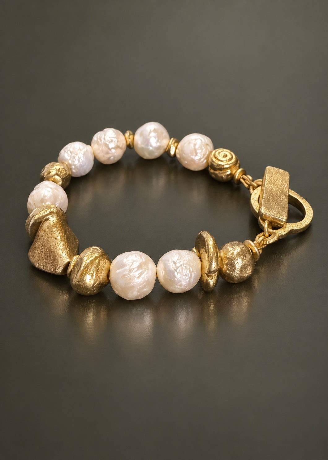 Poetic Pearl By Design freshwater pearl and cast brass bracelet on gray background