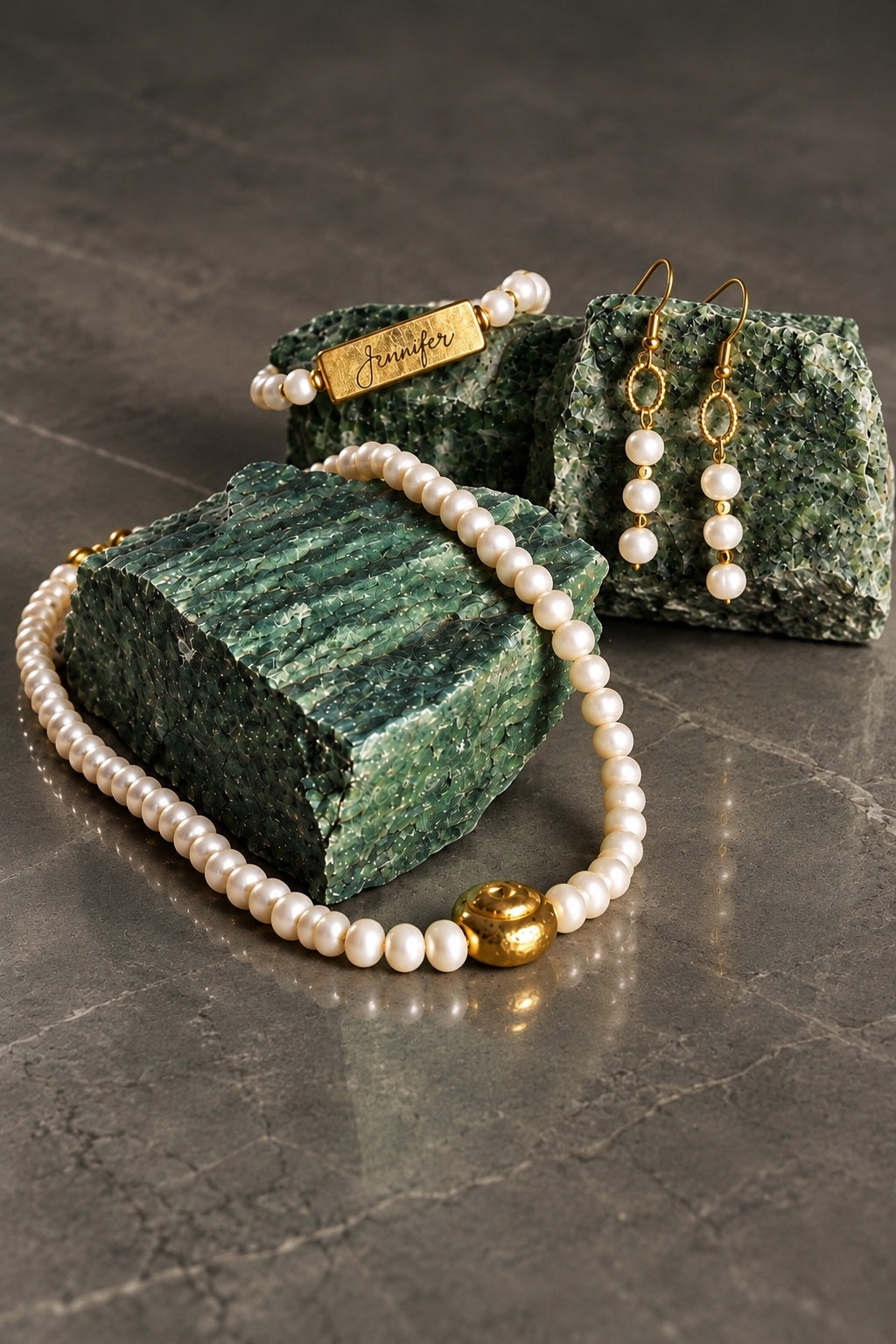 Full Circle pearl necklace styled on green stone with coordinating jewelry