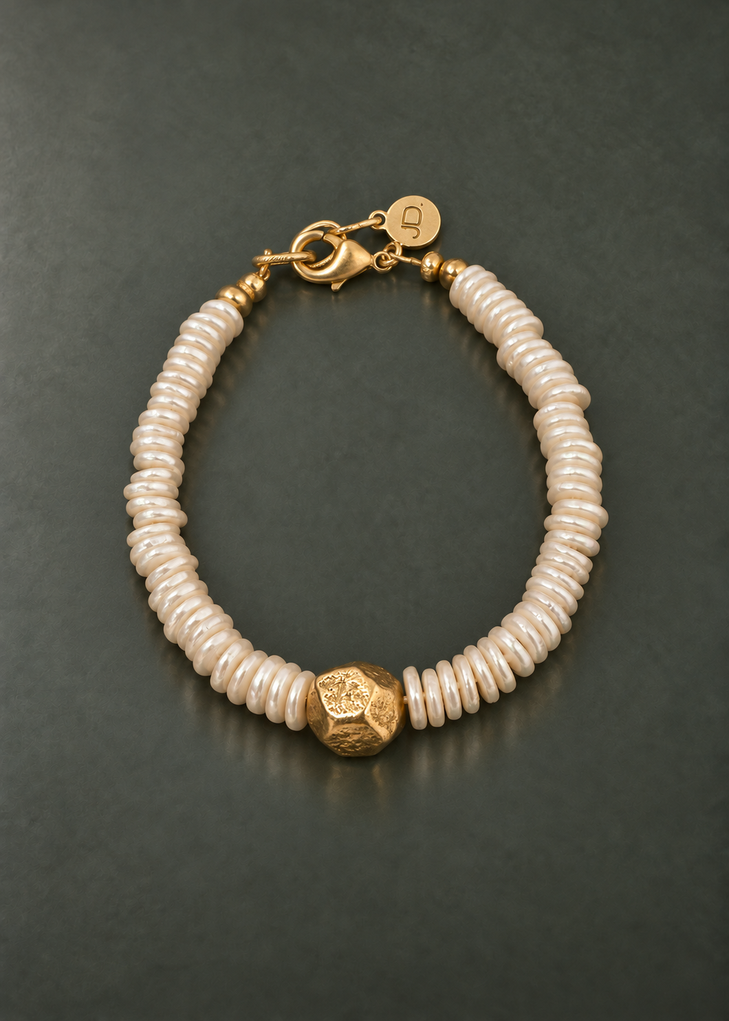 Poetic Pearl Golden Center shell pearl disc bracelet with a faceted brass center bead, overhead view