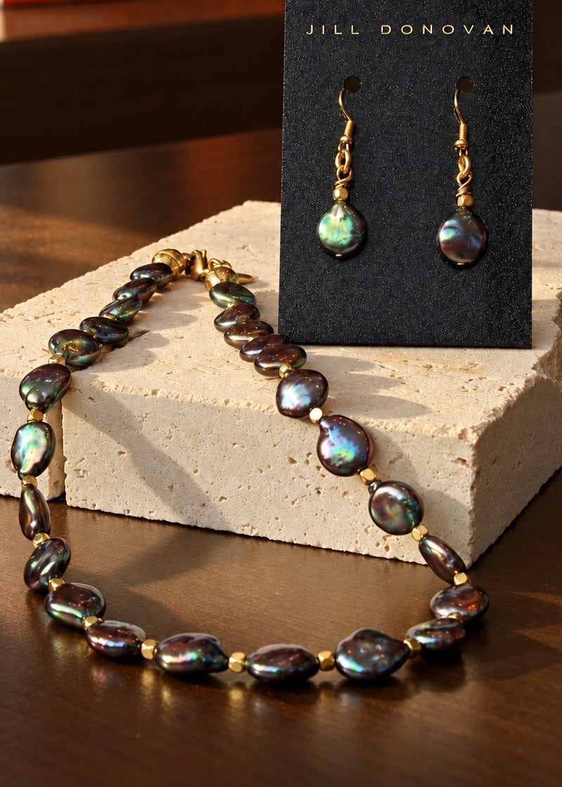 A Different Light freshwater pearl necklace and earring set displayed on stone