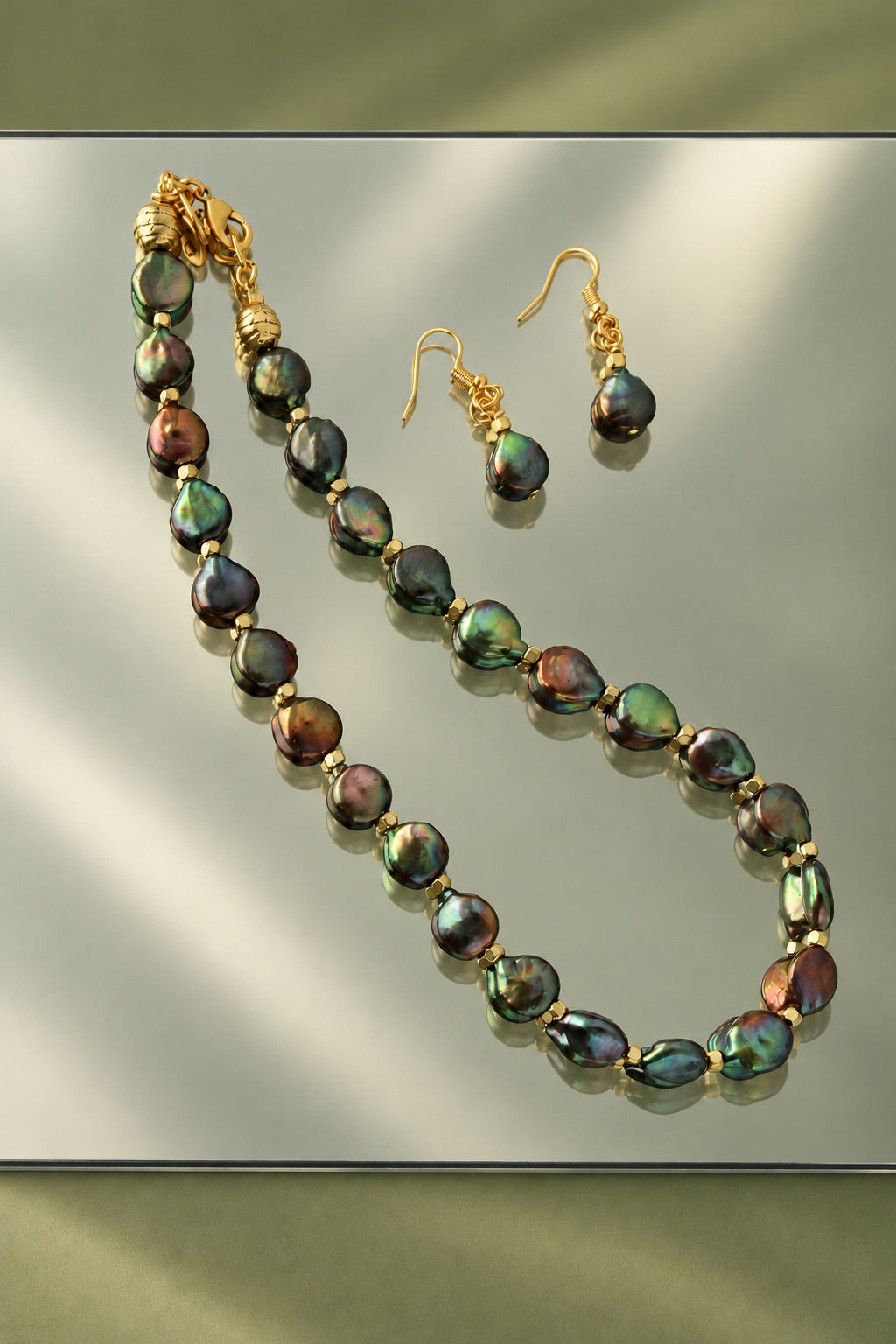 A Different Light necklace and earrings on a reflective surface
