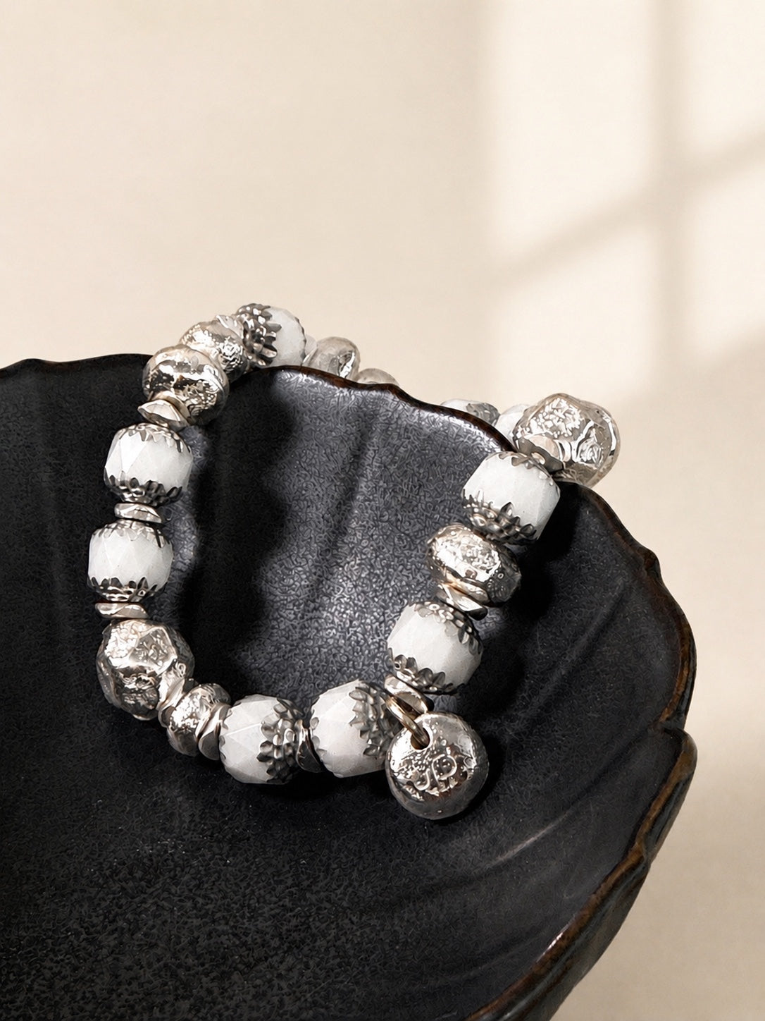 Cathedral White bracelet draped over a dark bowl