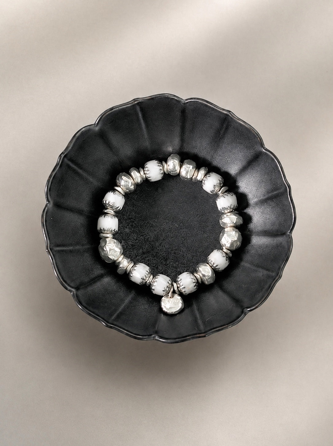 Cathedral White bracelet viewed from above in a dark bowl