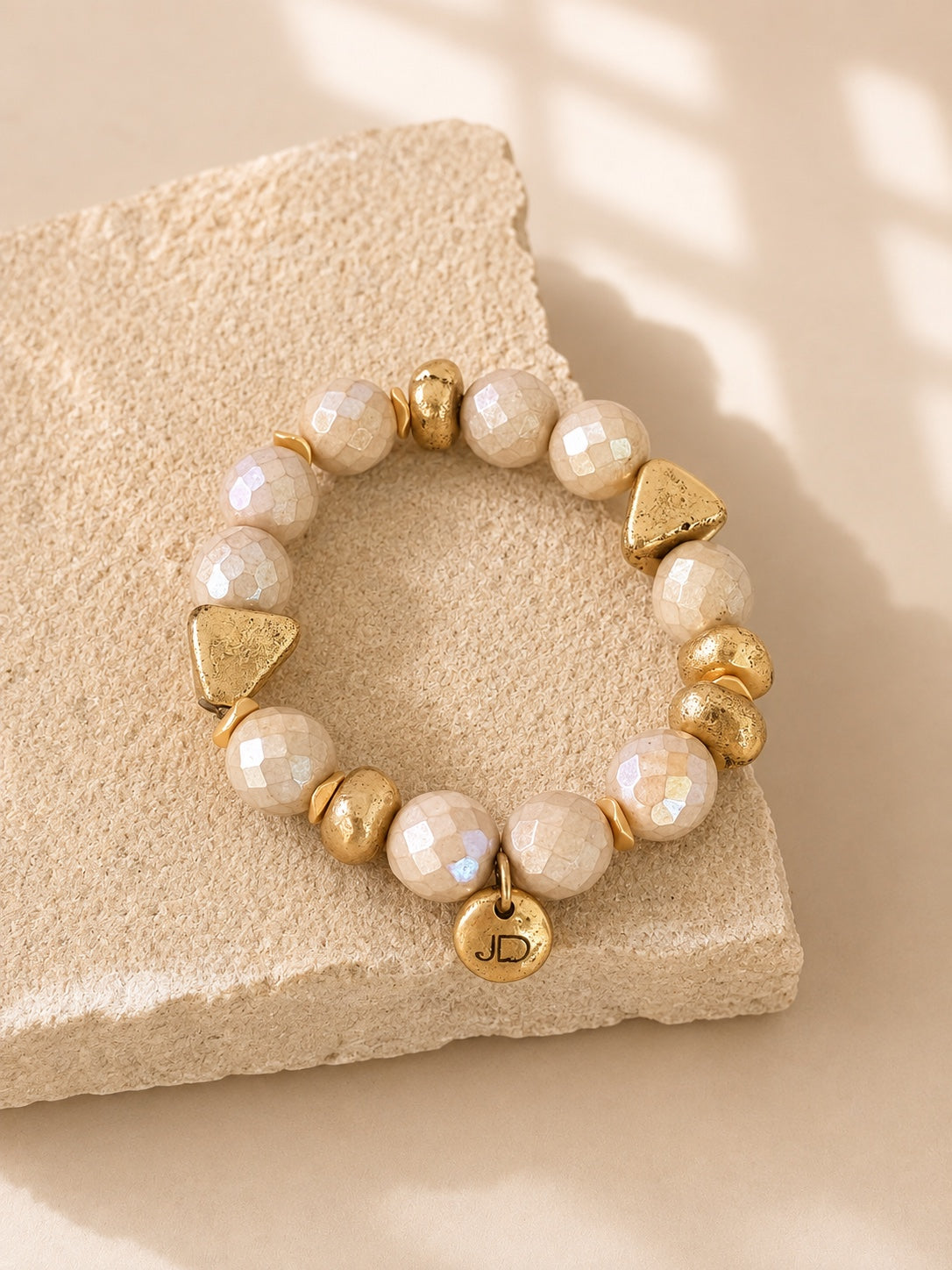 Champagne Afterglow bracelet with faceted cream glass beads and gold-tone cast brass accents.