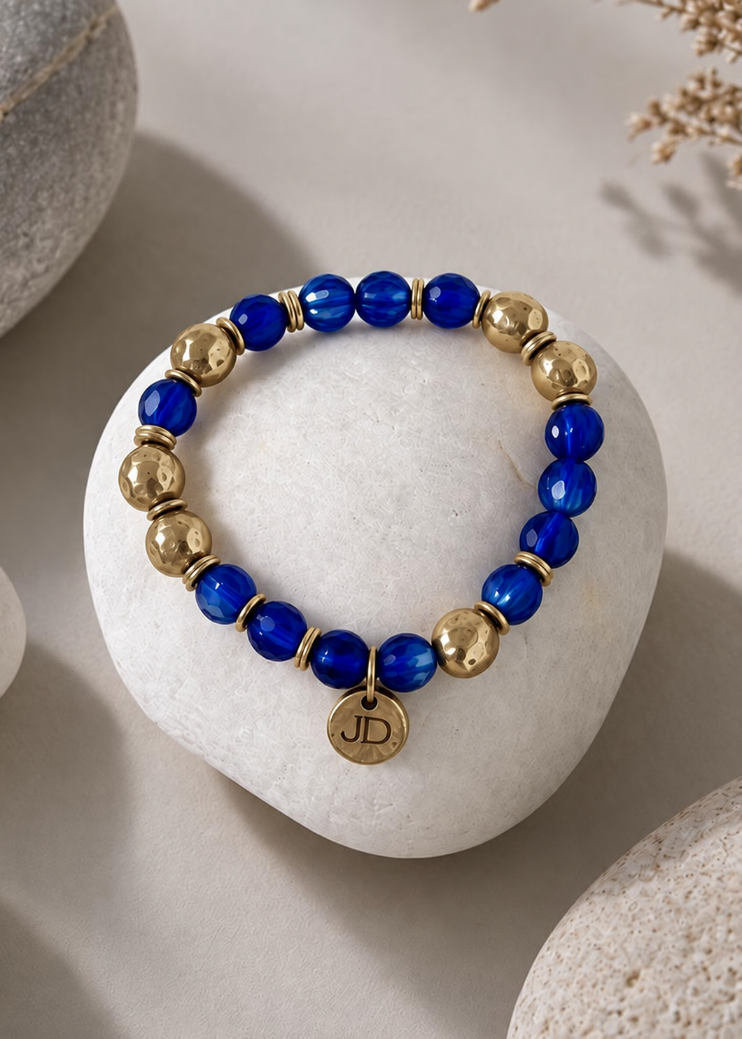 Cobalt Kiss bracelet with cobalt blue Czech glass beads and gold cast brass accents on a white stone.