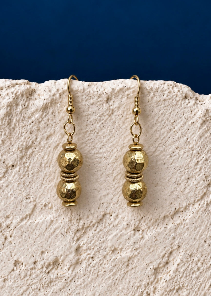 Golden Double Bead Earrings on white textured surface