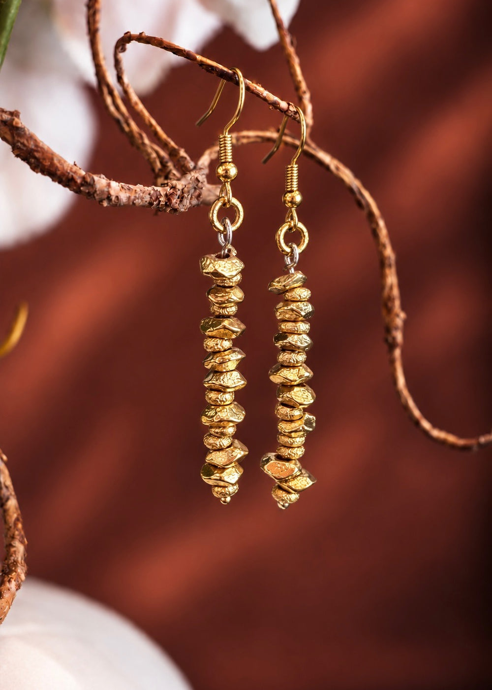 Golden Long Bead Drop Earrings hanging from a branch