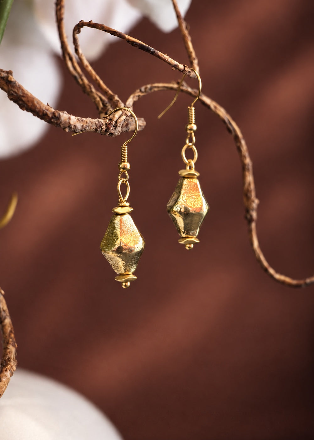 Golden Tapered Drop Earrings hanging from a branch