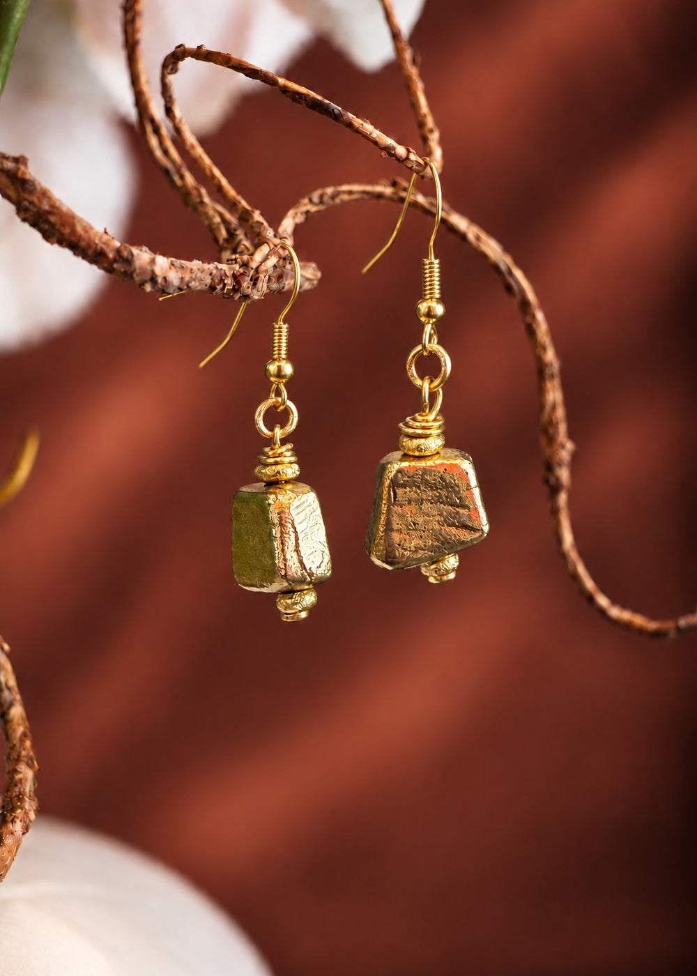 Golden Trapezoid Drop Earrings hanging from a branch