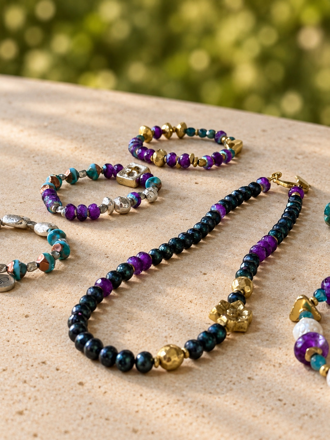 Where Magnolias Grow necklace with Gilded Garden bracelets on stone; pieces sold separately