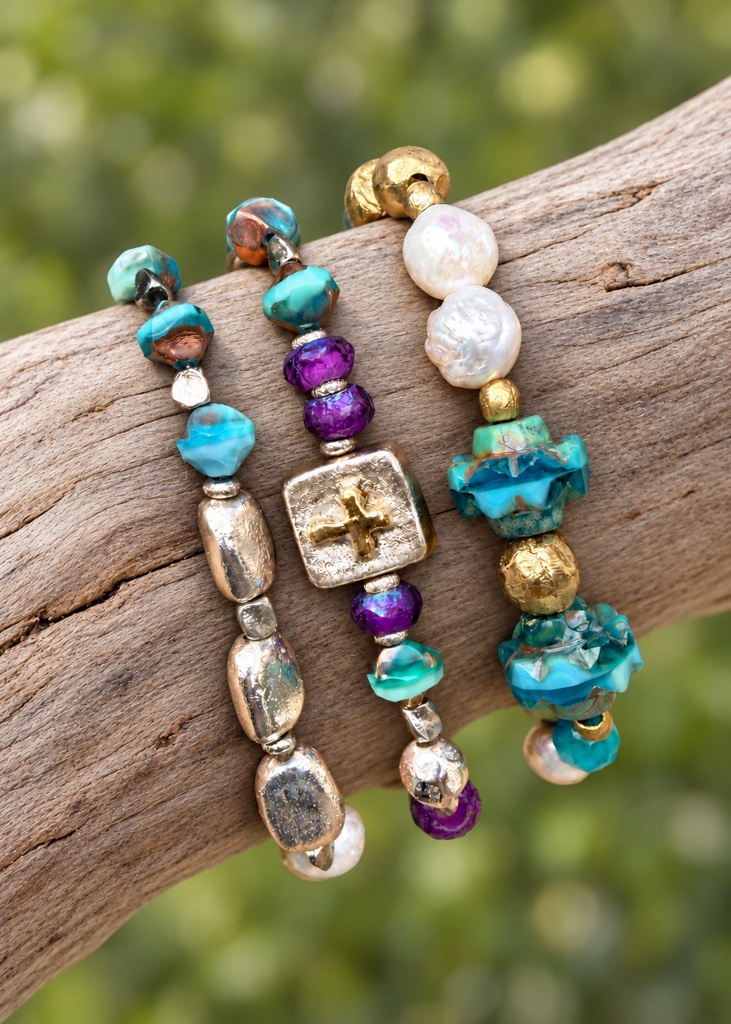 Silver Stepping Stones, Consider the Lilies, and Crown and Clover bracelets on driftwood; bracelets sold separately