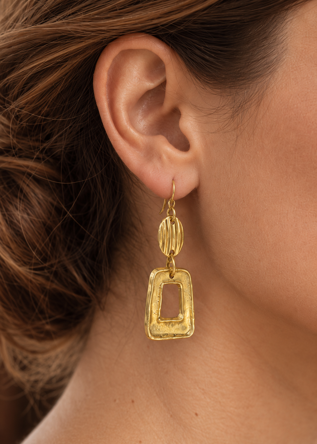 Close-up of Golden Open Frame Earrings worn on the ear