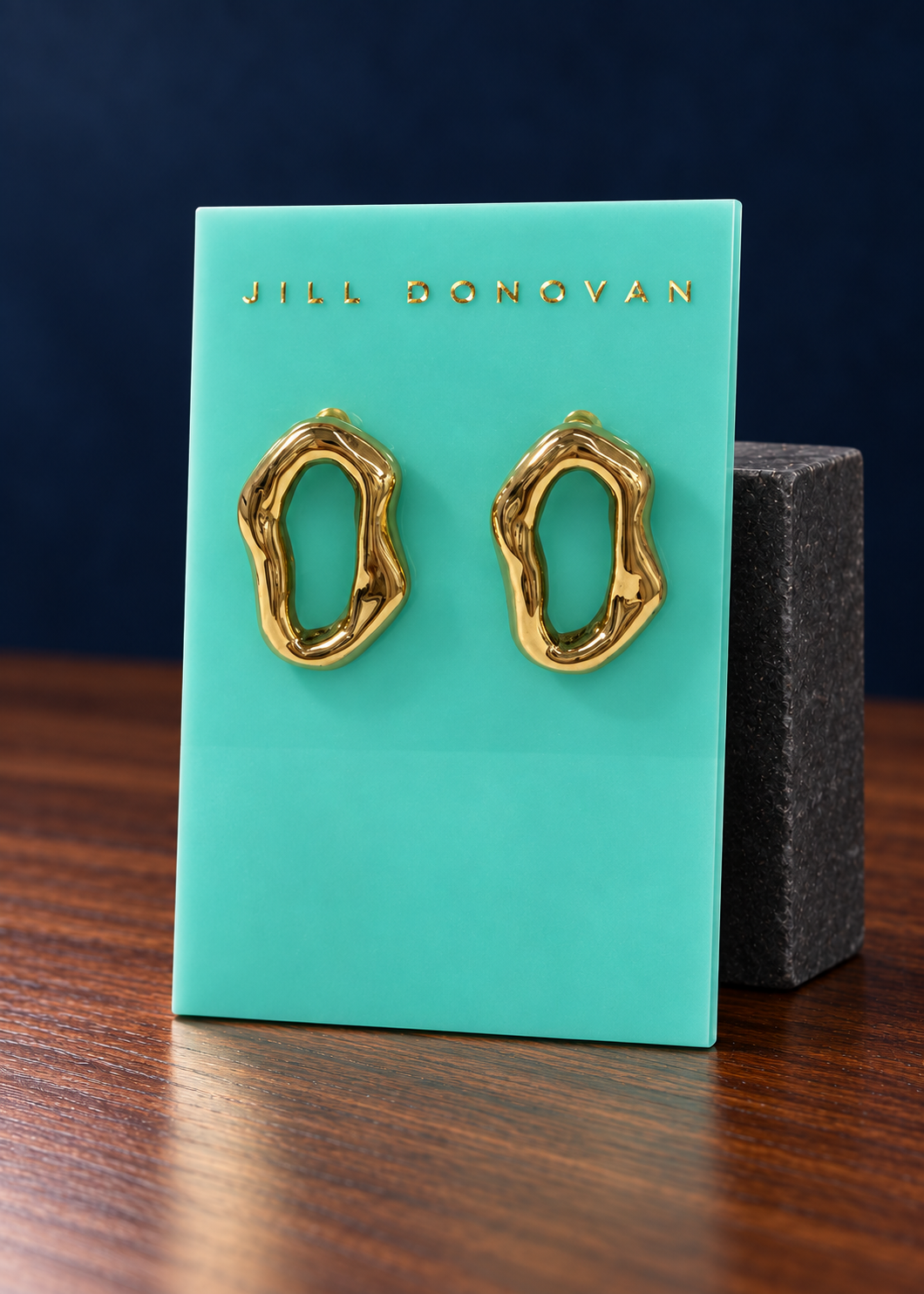 Golden Organic Oval Earrings — Only One Pair displayed on a lucite card