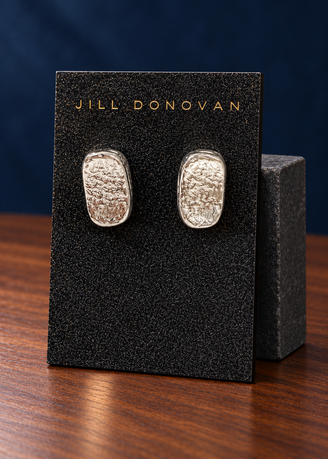 Silver Textured Oblong Earrings — Only One Pair displayed on a lucite card