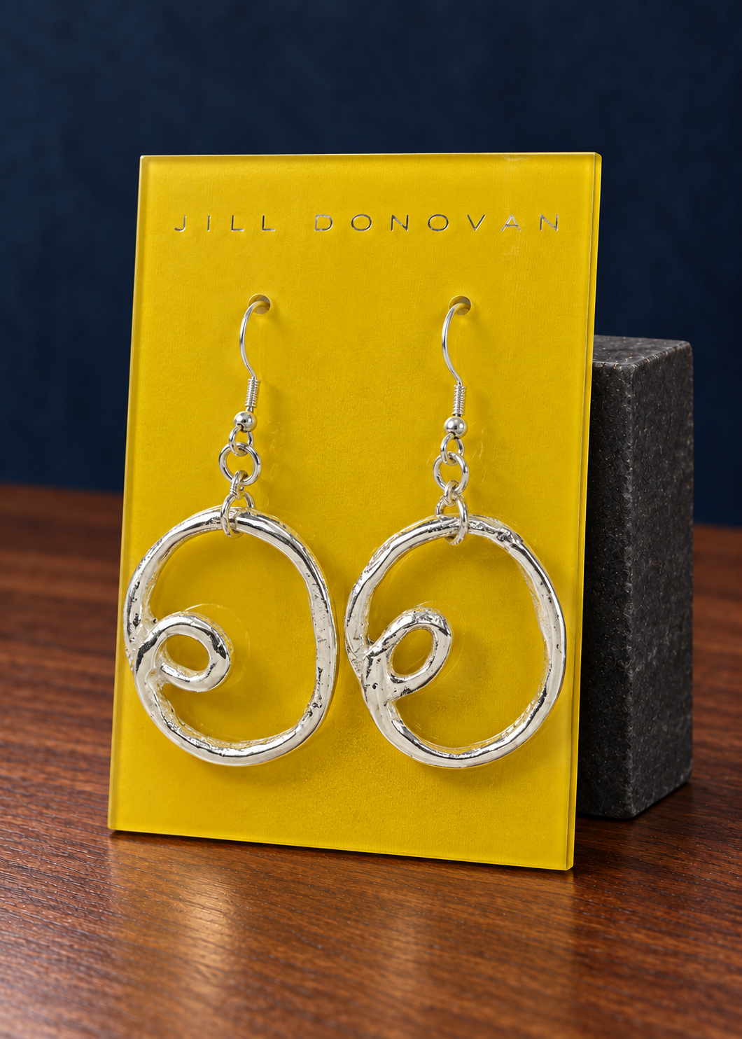 Silver Loop Drop Earrings — Only One Pair displayed on a lucite card