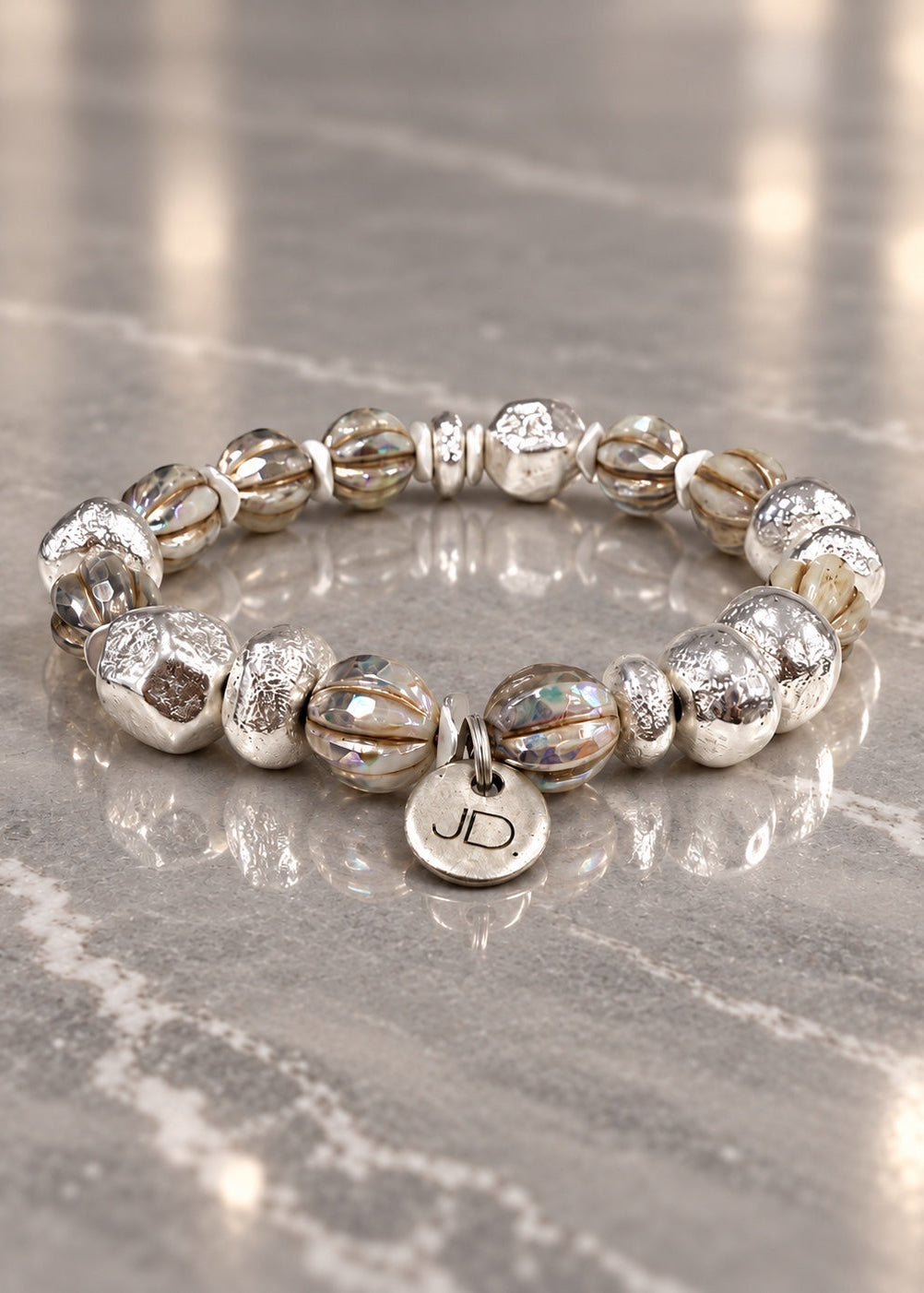 Silver Saturdays bracelet on a reflective gray counter.