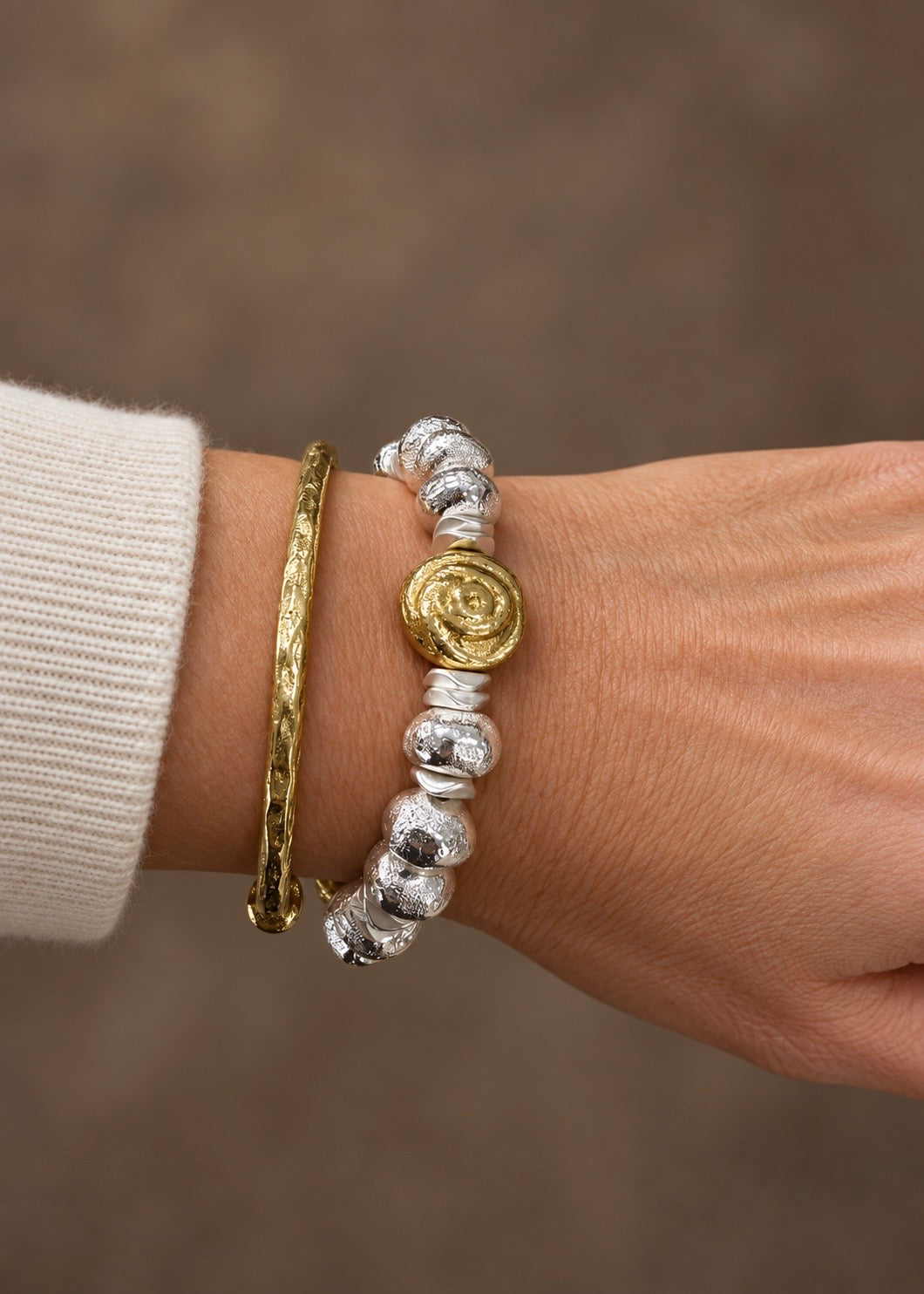 Triple Take bracelet worn on a wrist alongside a gold bangle